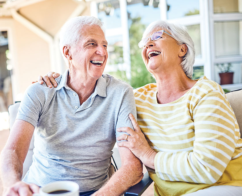 Laughing elderly couple drinking coffee